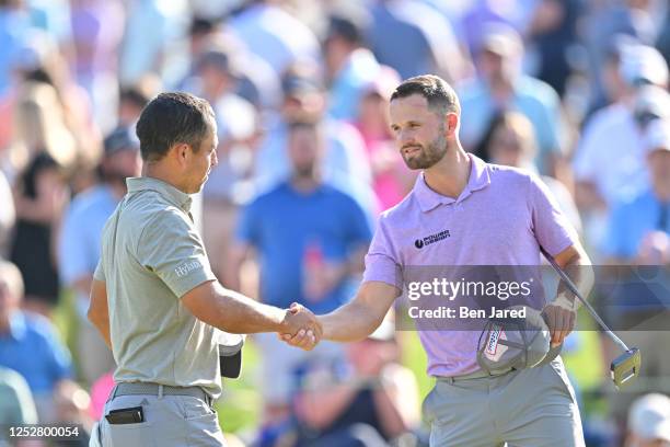Xander Schauffele and Wyndham Clark shake hands on the 18th green during the third round of the Wells Fargo Championship at Quail Hollow Club on May...
