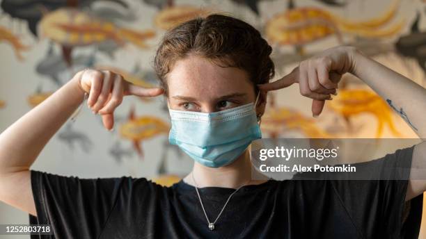 "i don't understand why?" 
19-years-old adolescent girl wearing a face mask looking into a camera - uncertainty pandemic stock pictures, royalty-free photos & images