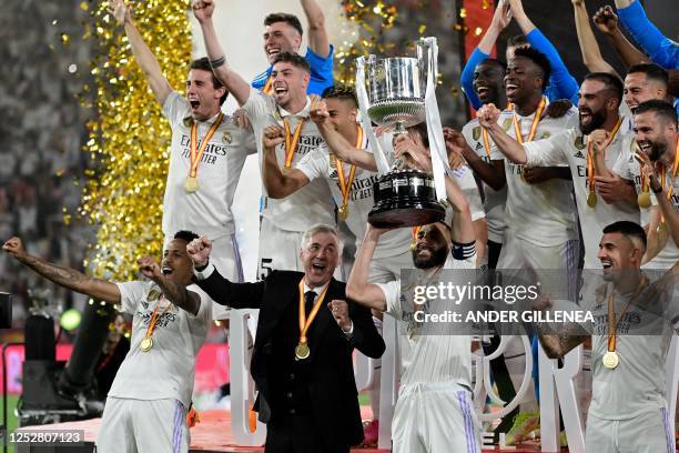 Real Madrid's French forward Karim Benzema , Real Madrid's Italian coach Carlo Ancelotti and teammates celebrate with the trophy after winning the...
