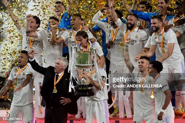 Real Madrid's French forward Karim Benzema , Real Madrid's Italian coach Carlo Ancelotti and teammates celebrate with the trophy after winning the...