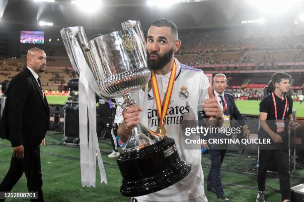 Real Madrid's French forward Karim Benzema poses for pictures with the trophy after winning the Spanish Copa del Rey final football match between...