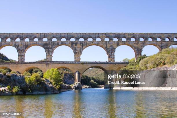 pont du gard, old roman aquaduct in southern france, with river gardon - aqueduct stockfoto's en -beelden