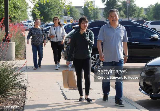 Plano residents Katherin Yan , her father Yulong Yan and her mother Hong Guo Yan with Katherine Luna of Allen walk away from the scene of a shooting...