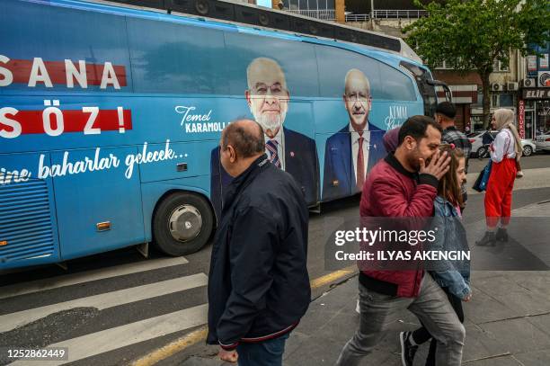 Pedestrians pass next to a election bus Republican People's Party at the historical Sur district in Diyarbakir, southeastern Turkey, on May 1, 2023....