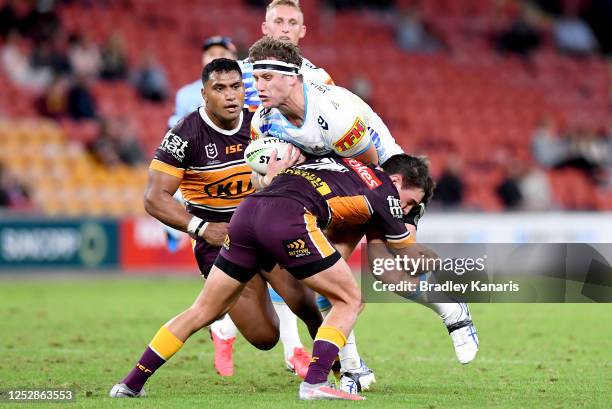 Jarrod Wallace of the Titans takes on the defence of Brodie Croft of the Broncos during the round seven NRL match between the Brisbane Broncos and...