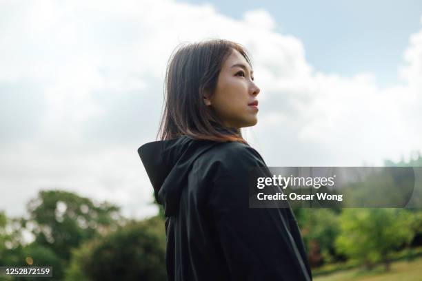 confident young woman planning her future - young woman standing against clear sky ストックフォトと画像