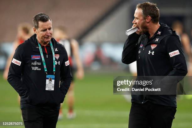 Bombers head coach John Worsfold and Bombers assistant coach Ben Rutten speak during the round 4 AFL match between the Essendon Bombers and the...