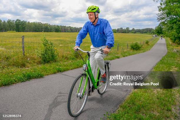 King Philippe of Belgium smiles while riding a bike during a visit with Princess Elisabeth of Belgium, Prince Gabriel of Belgium, Prince Emmanuel of...