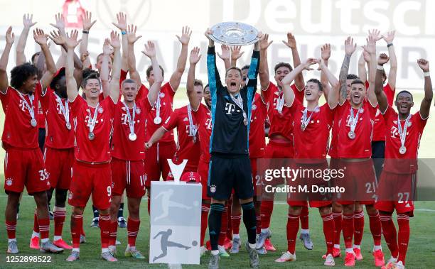 Manuel Neuer of Bayern Muenchen lifts the trophy next to his teammates during the Bundesliga match between VfL Wolfsburg and FC Bayern Muenchen at...