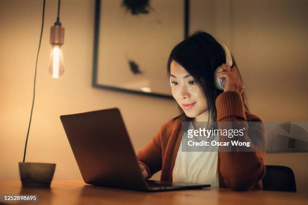 young woman remote learning at home with laptop - asian cinema bildbanksfoton och bilder