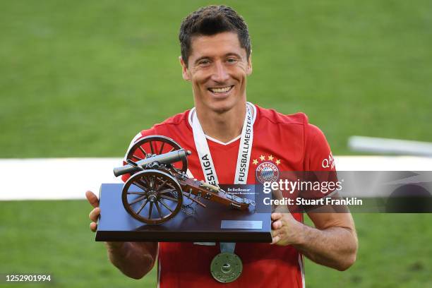 Robert Lewandowski of Bayern Muenchen poses with the trophy for the top goalscorer of the season after the Bundesliga match between VfL Wolfsburg and...