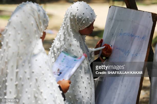 Afghan school girls attend a class at an open air primary school in Jalalabad on May 7, 2023.