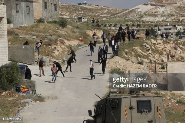 Palestinian protesters throw stones towards Israeli troops during confrontations as army bulldozers demolished a school that the Israeli authorities...