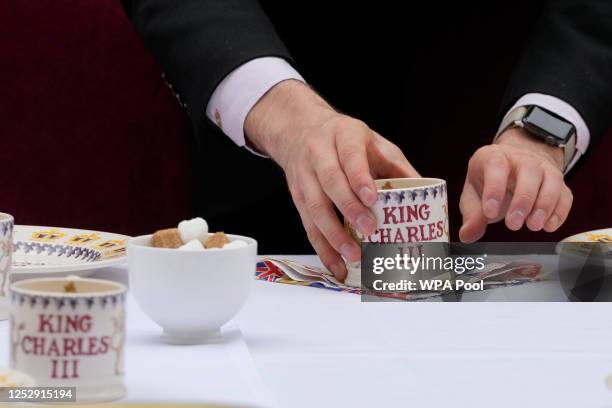 Waiter puts the finishing touches to a place setting for Prime Minister Rishi Sunak's Big Lunch party at Downing Street on May 7, 2023 in London,...