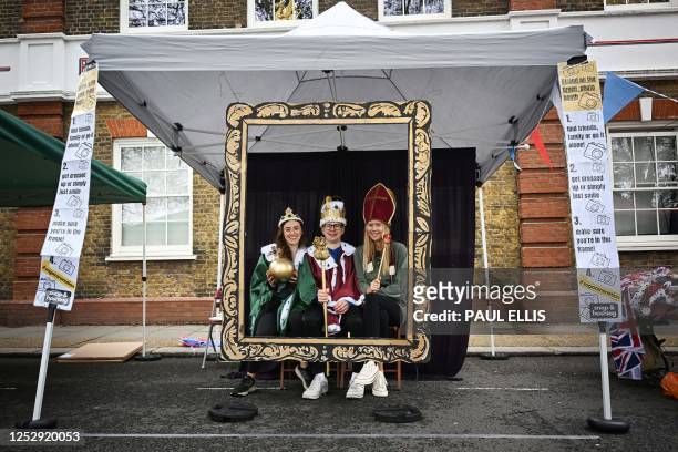 Members of the public pose for photographs in a Coronation Selfie booth at a street party in Chiswick, west London, as part of the Coronation Big...