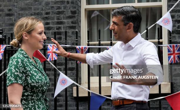 Britain's Prime Minister Rishi Sunak speaks with US First Lady's grand daughter Finnegan Biden during a Coronation Big Lunch organised in Downing...