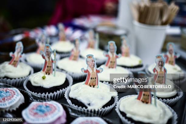 Cup cakes with a figurine of Britain's King Charles III are displayed on a tray during a Coronation Big Lunch in Regent's Park, in central London, on...