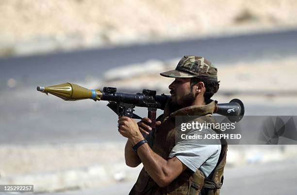 Fighter loyal to Libya's new leaders readies to fire his Rocket Propelled Grenade during clashes with pro-Kadhafi armed men inside the city of Bani...