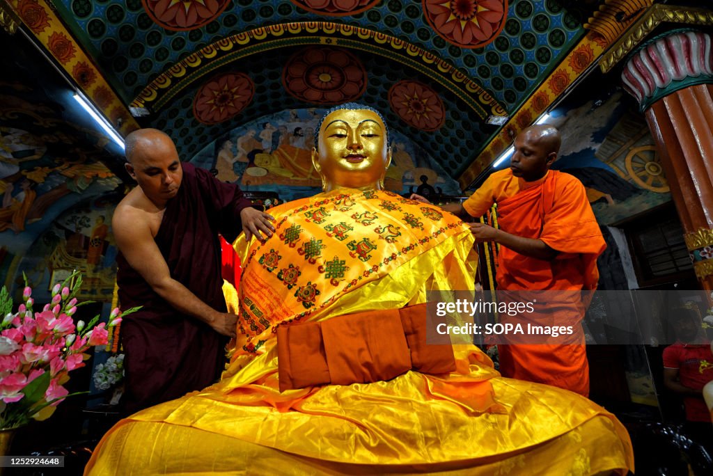 Buddhist monks preparing the statue of Gautama Buddha at the...