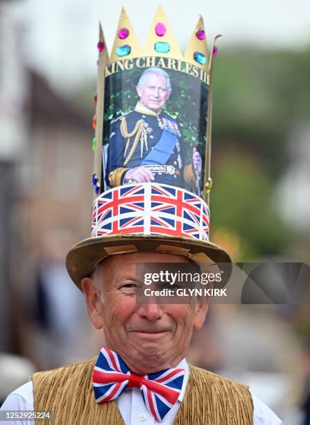 Resident wearing a crown poses for a photograph during a Coronation Big Lunch, in Alfriston, southern England, on May 7, 2023. - Thousands of local...