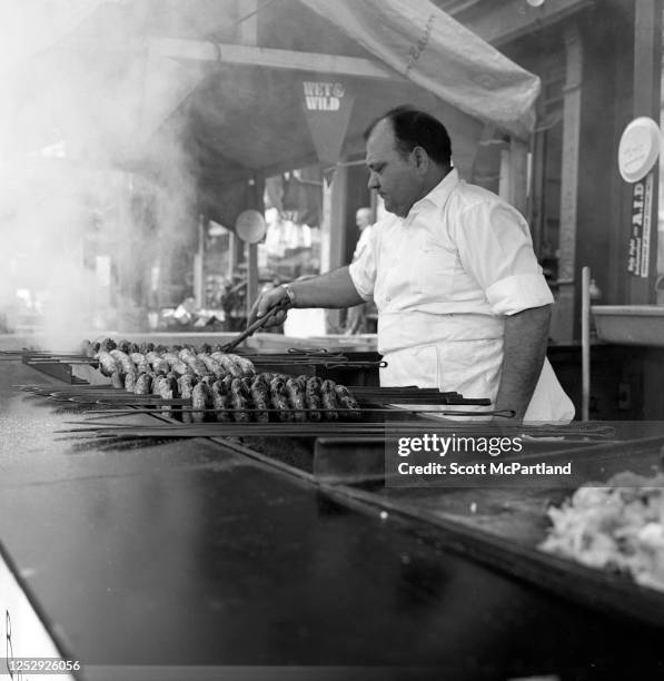 View of a man grilling skewered meats at a booth on Mulberry Street during the Feast Of San Gennaro Festival, in the Little Italy neighborhood, New...