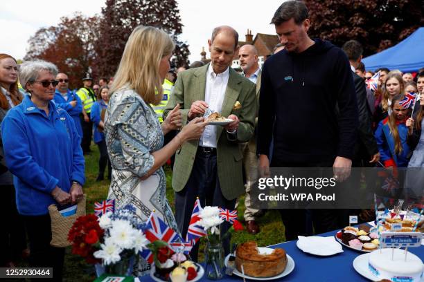 Britain's Prince Edward, Duke of Edinburgh and Sophie, Duchess of Edinburgh taste a coronation chicken pie as they attend a Big Lunch with residents...