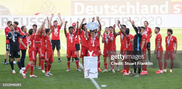 Philippe Coutinho of FC Bayern Muenchen lifts the trophy to celebrate the championship following the Bundesliga match between VfL Wolfsburg and FC...