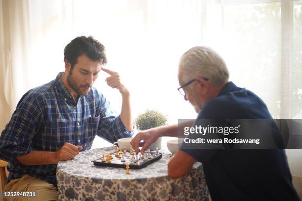 chess playing with family - senior playing chess stock pictures, royalty-free photos & images