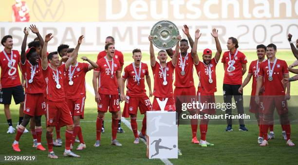 Mickaël Cuisance of FC Bayern Muenchen lifts the trophy to celebrate the championship following the Bundesliga match between VfL Wolfsburg and FC...