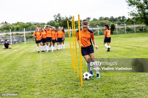 jogadora de futebol feminino praticando com uma bola - high school football - fotografias e filmes do acervo