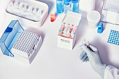 Quick novel COVID-19 coronavirus test kit. 2019 nCoV pcr diagnostics kit. Hand in glove with the box. The kit detects covid19 virus in patients samples. Тesting system for real-time PCR amplification.
