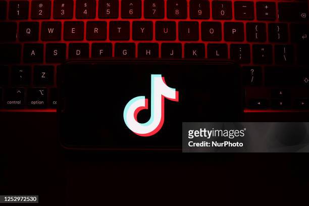 Laptop keyboard and TikTok logo displayed on a phone screen are seen in this illustration photo taken in Krakow, Poland on May 7, 2023.