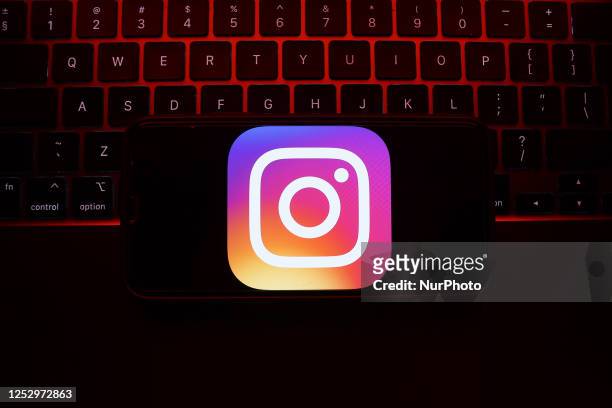 Laptop keyboard and Instagram icon displayed on a phone screen are seen in this illustration photo taken in Krakow, Poland on May 7, 2023.