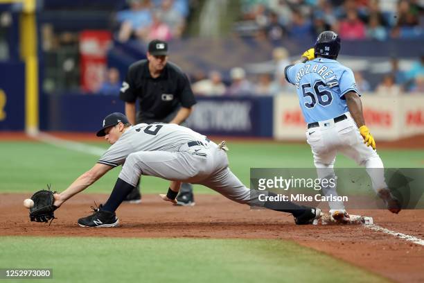 Randy Arozarena of the Tampa Bay Rays is safe at first base as DJ LeMahieu of the New York Yankees reaches for a late throw during the third inning...
