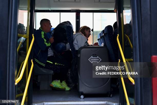 Venezuelan migrants board a bus upon arrival at the Simon Bolivar International Airport in Maiquetia, La Guaira State, Venezuela, on May 7, 2023. - A...