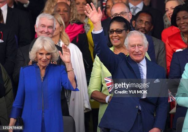 Britain's King Charles III and Britain's Queen Camilla wave as they arrive to attend the Coronation Concert at Windsor Castle in Windsor, west of...
