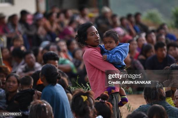 People wait at a temporary shelter in a military camp, after being evacuated by the Indian army, as they flee ethnic violence that has hit the...