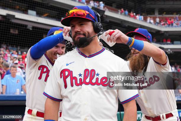 Bryson Stott and Brandon Marsh of the Philadelphia Phillies pour water on Kyle Schwarber during his postgame interview against the Boston Red Sox at...