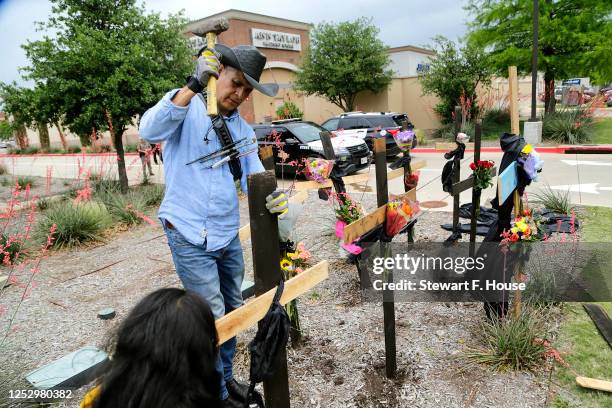 Roberto Marquez of Dallas constructs a wooden cross memorial at the scene of a mass shooting a day earlier at Allen Premium Outlets on May 7, 2023 in...