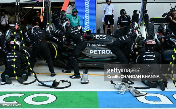 Crew members work on the car of Mercedes' British driver Lewis Hamilton in the pitlane during the 2023 Miami Formula One Grand Prix at the Miami...