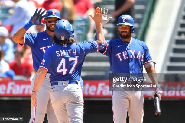 Texas Rangers Outfield Josh H. Smith gets a high five from Texas Rangers second baseman Marcus Semien after crossing home plated after hitting a home...