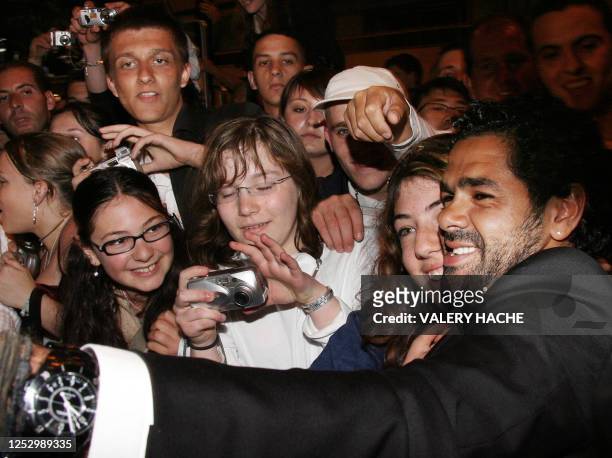 French actor Djamel Debbouze poses with a fan upon leaving the Festival Palace following the premiere of French director Rachid Bouchareb's film...