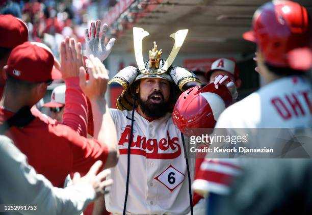 Anthony Rendon of the Los Angeles Angels celebrates in the dugout after hitting a three-run home run to score Mike Trout and Shohei Ohtani during the...