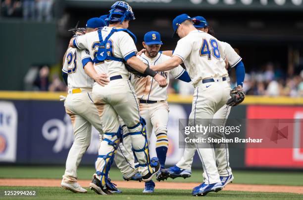 Second baseman Jose Caballero of the Seattle Mariners, center, first baseman Ty France, catcher Cal Raleigh and relief pitcher Justin Topa celebrate...