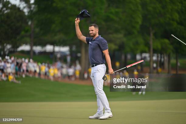 Wyndham Clark waves his hat after making the winning putt on the 18th green during the final round of the Wells Fargo Championship at Quail Hollow...
