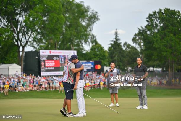 Wyndham Clark hugs his caddie, John Ellis, on the 18th green after making the winning putt during the final round of the Wells Fargo Championship at...