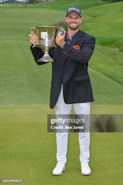 Wyndham Clark holds the trophy near the 18th green after the final round of the Wells Fargo Championship at Quail Hollow Club on May 7, 2023 in...