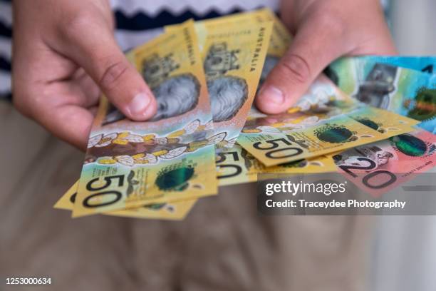 male person holding some australian currency - australian money stock pictures, royalty-free photos & images