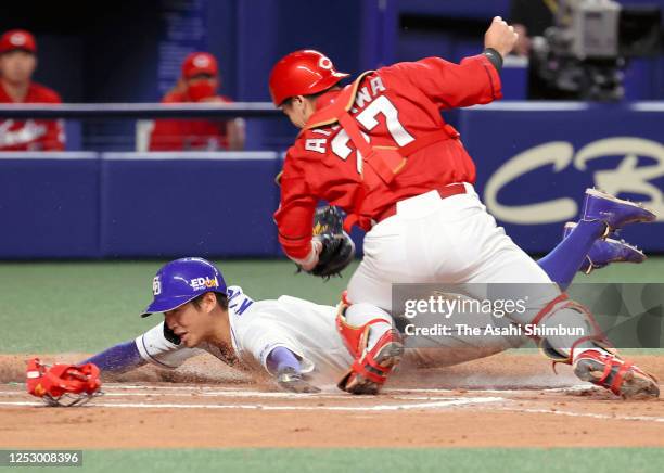 Yota Kyoda of the Chunichi Dragons slides safely into the home base to score a run by a RBI single of Zoilo Almonte in the 6th inning during the game...