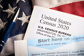 Census 2020: survey questionnaire form on desk with pen and usa flag
